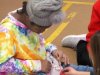 Child at Saturday Kids Club, part of Stepping Stones Ohio opens her holiday gift.