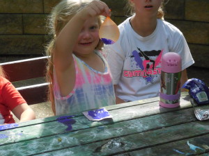 Remington from the Aphids dips her water balloon in paint!