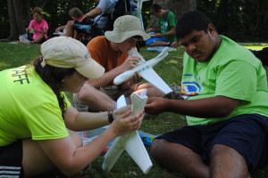 Abby and a participant building a plane for the camp-wide activity for week 5