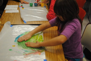 Mixing colors while finger painting with pudding!
