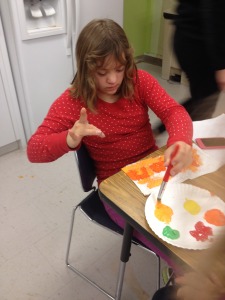Grace paints her Thanksgiving Potholder!